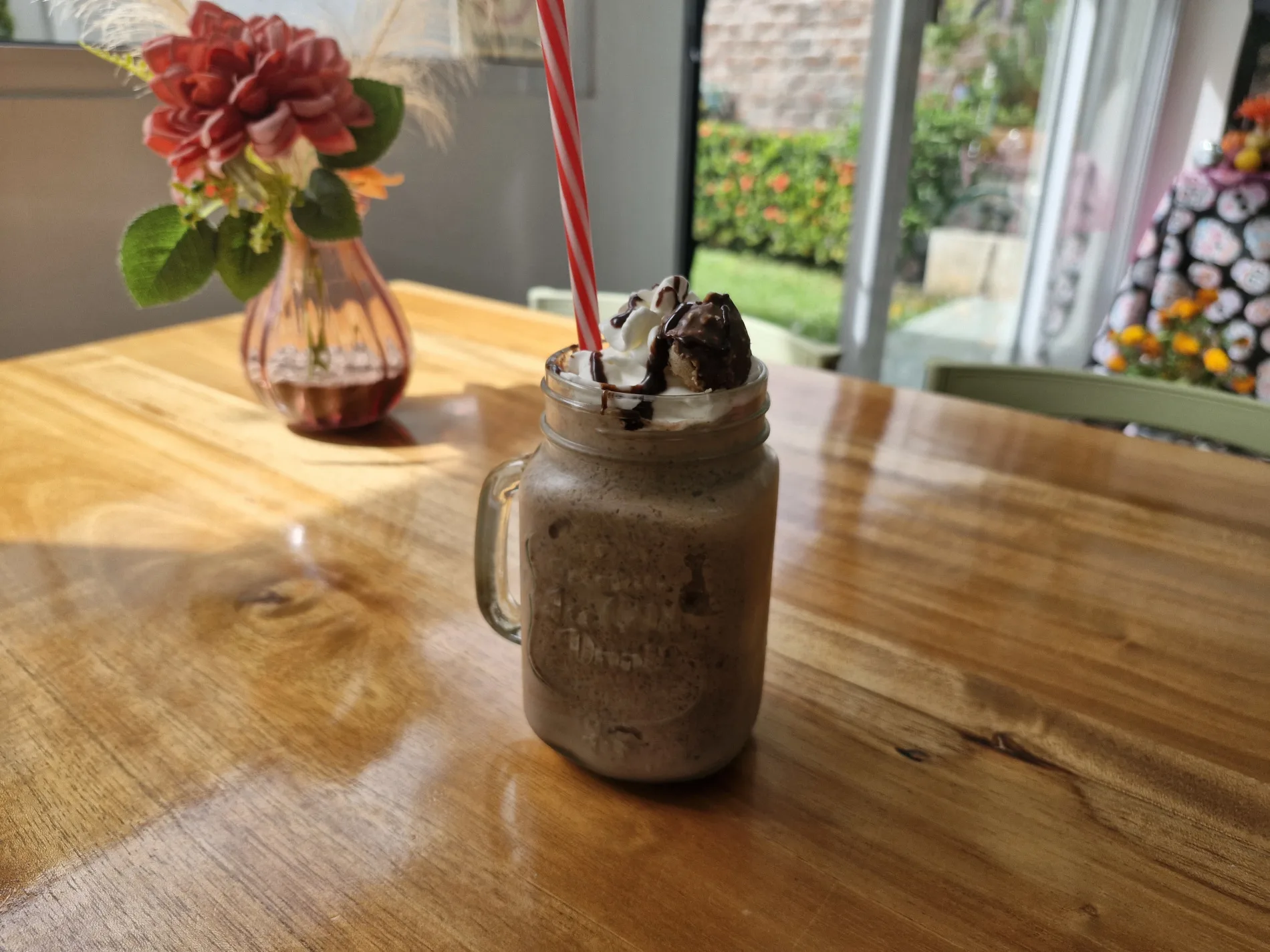 Frappe Mamut servida en mesa de Kass Bakery & Restaurant, con letrero decorativo al fondo.